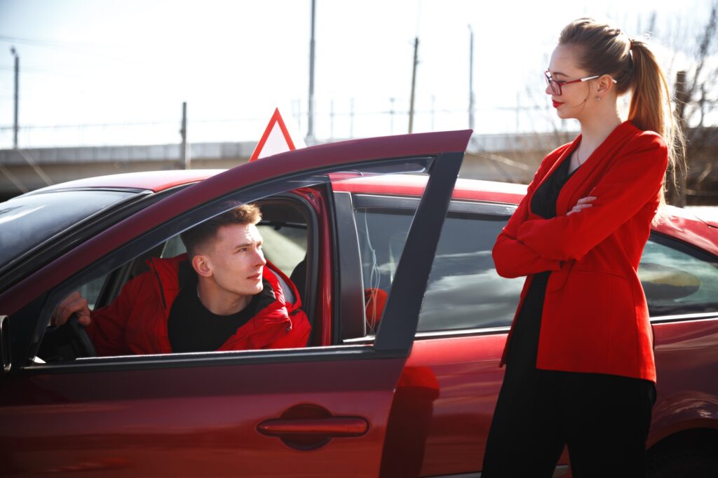 Driving instructor and woman student in examination car.