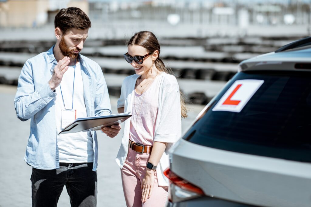 Instructor with female student at the driving school outdooors