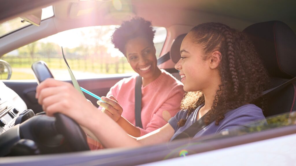 Teenage Girl In Car Having Driving Lesson From Female Instructor