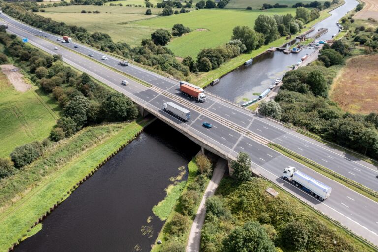 Aerial view directly above a busy UK motorway bridge over a river